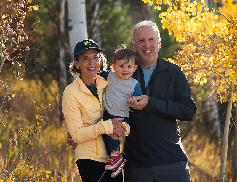 Portrait photo of Jennifer and Tom Hillman with their grandson